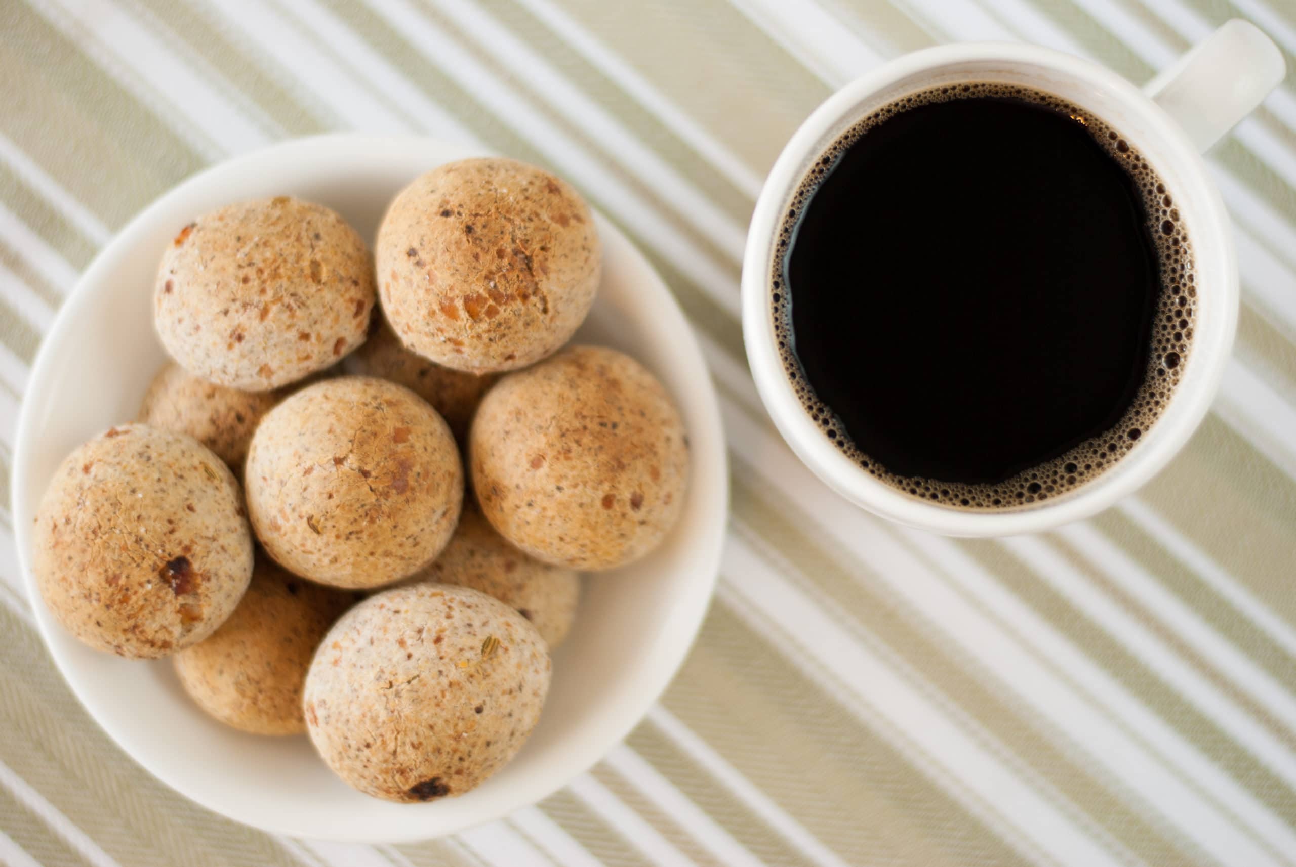 Brazilian cheese bread in a bowl with cup of black coffee