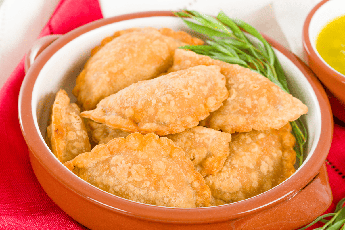 pastel de queijo on a serving platter with dipping sauce
