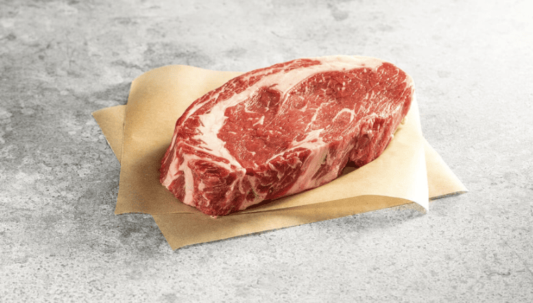 raw ribeye steak on butcher paper